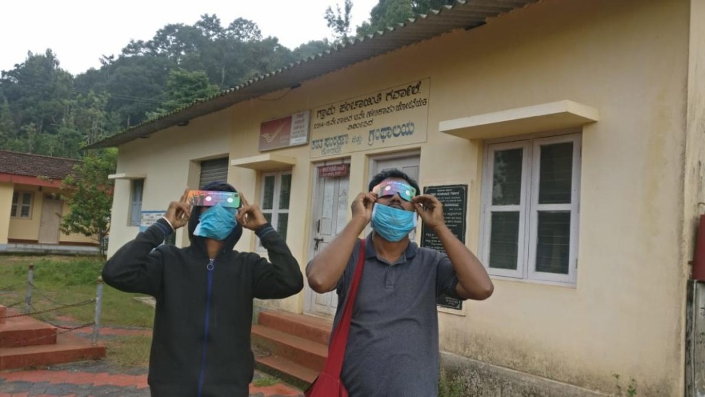 People watch solar eclipse using goggles in government high school in Soorlabbi near Madapura on Sunday. DH Photo 