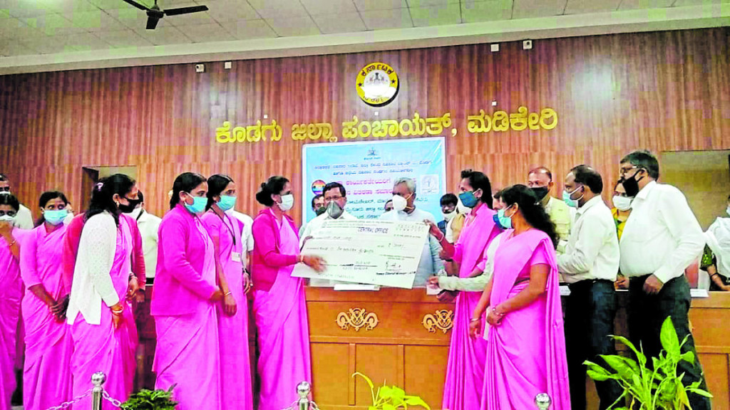 Cooperation Minister S T Somashekhar distributes the cheques to Asha workers during a programme held at the Zilla Panchayat auditorium in Kodagu on Thursday. DH Photo 